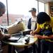 Michigan junior Takis Bletsis, Kokomo, Ind., Sophomore James Giardina, Rochester and Patrick Kosnik, Grand Rapids, purchase copies of Desmond Howard's new book ?I Wore 21: The Legend of Desmond Howard? before an autograph signing at the M Den on Friday.  Melanie Maxwell I AnnArbor.com